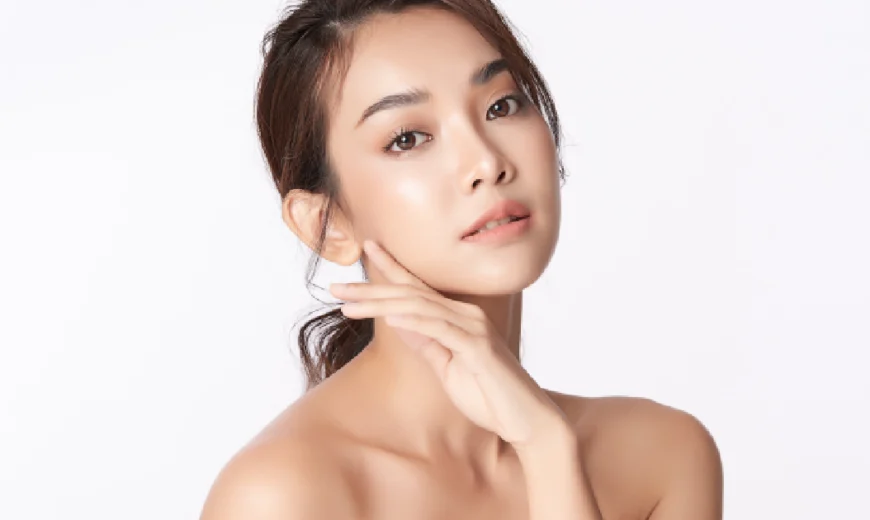 Young woman with flawless skin gently touching her face, showcasing a smooth, glowing complexion after a Préime Derma Facial in Leesburg, FL.